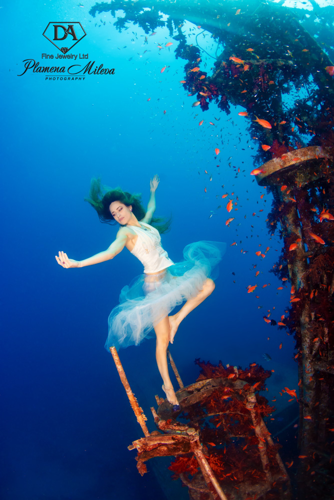 © Plamena Mileva | The incredible Satil Wreck has been an inspiration to many photographers. The intense red coral that covers the boat and the amount of small fish life that surrounds it, makes this shipwreck a beautiful sea life environment. I placed my dancer as if she was one of those dolls in a musical box, which as soon as you open attract you with its music and beauty. Can you remember these small ballet dancers which swivelled in a music box?  An old childhood memory that I relate to the beauty of this sunken wreck, surrounded with sea life. All the pictures I took in Eilat Red Sea Competition are carried out with: Canon 5D Mark III, Ikelite housing, 2 X 161 DS Ikelite strobes, Tokina 10-17mm f/3.5 -4.5 with trimmed hood