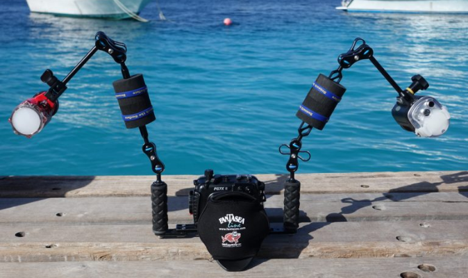 Dual underwater strobes positioned at approximately 45 degrees for wide-angle reef photography